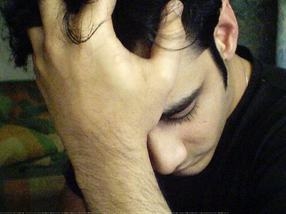 Hombre deprimido se sujeta la cabeza con la mano. SUperar la depresión